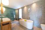 This stunning bathroom boasts a modern design with a luxurious freestanding bathtub, perfect for relaxation.