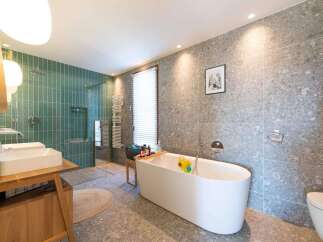 This stunning bathroom boasts a modern design with a luxurious freestanding bathtub, perfect for relaxation.