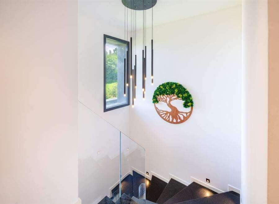 This stunning property features a modern staircase with sleek glass railings and dark stone steps.