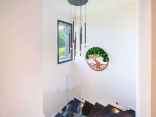 This stunning property features a modern staircase with sleek glass railings and dark stone steps.
