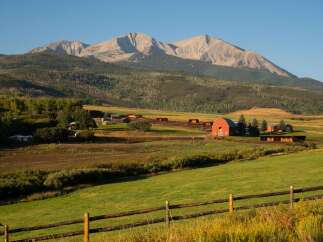 Nestled in a picturesque landscape, this stunning property boasts a charming red barn and expansive green fields.