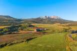 Discover the tranquility of this stunning rural property, featuring a picturesque red barn and expansive green fields.