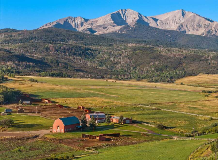 Nestled in a picturesque valley, this stunning property boasts a sprawling ranch with a backdrop of majestic mountains.