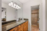 This stunning bathroom features a sleek granite countertop and custom wooden cabinetry, offering both style and functionality.