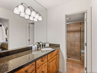 This stunning bathroom features a sleek granite countertop and custom wooden cabinetry, offering both style and functionality.