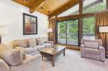Experience mountain living in this cozy living room featuring a plush sectional sofa and a comfortable armchair, perfect for relaxing after a day of adventure.