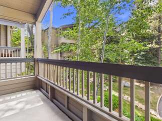 Enjoy the fresh mountain air from this charming balcony, offering serene views of lush greenery and surrounding architecture.