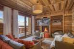 Experience the warmth of this stunning chalet living room, featuring a cozy fireplace and inviting seating.