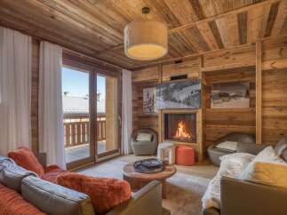 Experience the warmth of this stunning chalet living room, featuring a cozy fireplace and inviting seating.