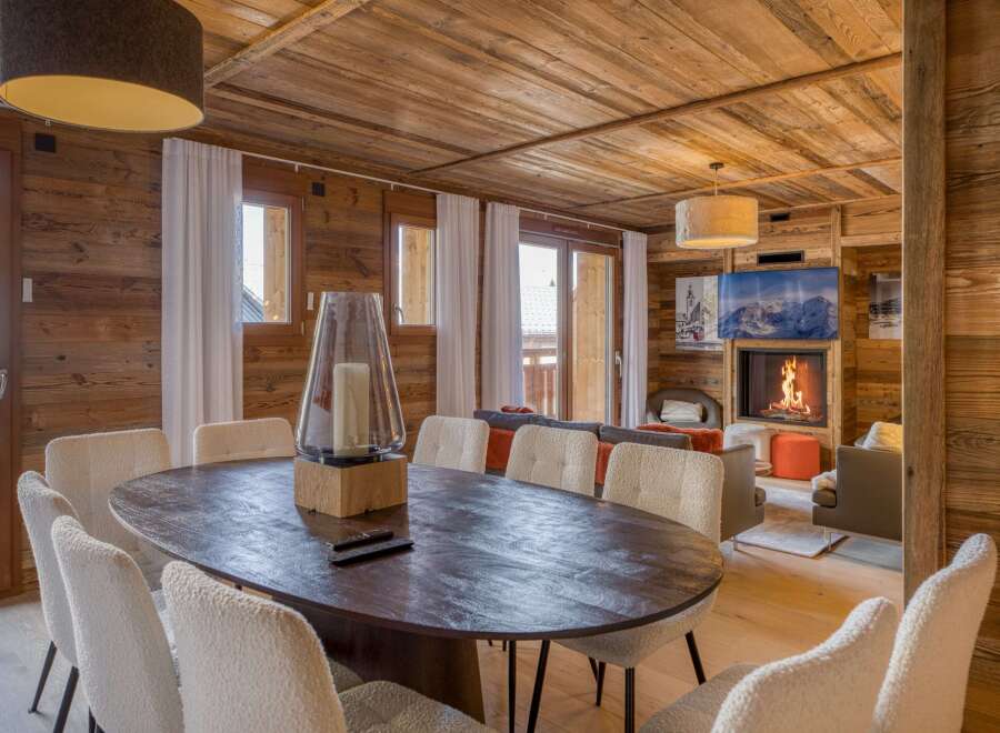 Experience the warmth of this stunning chalet, featuring a cozy fireplace and a rustic wooden interior.
