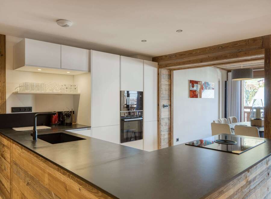 This modern kitchen boasts a sleek design with a dark countertop and white cabinetry, creating a stylish and functional space.