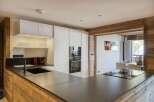 This modern kitchen boasts a sleek design with a dark countertop and white cabinetry, creating a stylish and functional space.