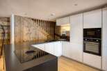 This stunning kitchen boasts a modern design with sleek white cabinetry and a contrasting black countertop.
