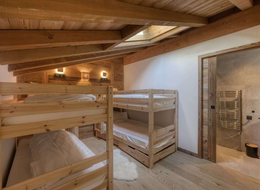 This cozy bedroom features custom-built wooden bunk beds, perfect for accommodating guests or family.