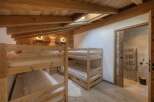 This cozy bedroom features custom-built wooden bunk beds, perfect for accommodating guests or family.