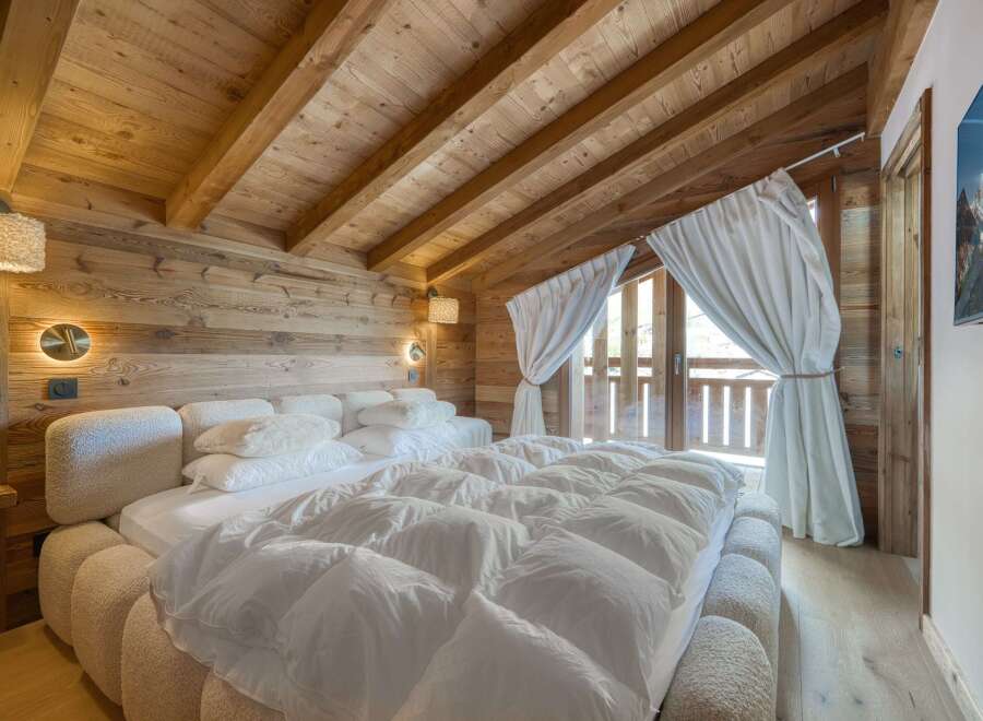 This stunning bedroom showcases a rustic, yet luxurious design with its wooden walls and ceiling.