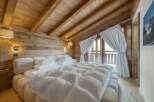 This stunning bedroom showcases a rustic, yet luxurious design with its wooden walls and ceiling.