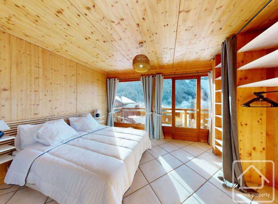 Experience the charm of this cozy bedroom, featuring warm wooden accents and a stunning view.