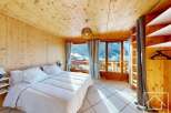 Experience the charm of this cozy bedroom, featuring warm wooden accents and a stunning view.