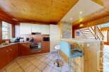This charming kitchen boasts a warm, inviting atmosphere with its wooden ceiling and cabinetry.