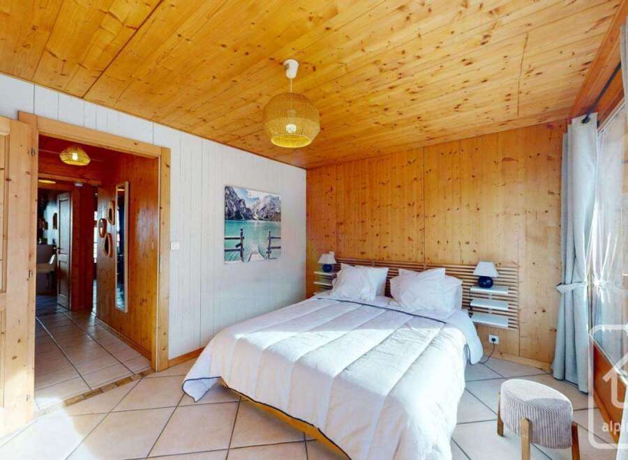 Experience the warmth of this inviting bedroom, featuring stunning wood paneling and a cozy ambiance.