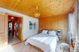 Experience the warmth of this inviting bedroom, featuring stunning wood paneling and a cozy ambiance.