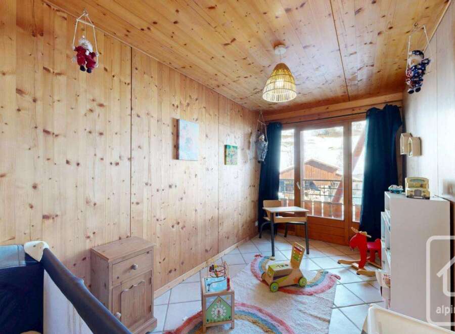 This charming children's room features warm wooden paneling and a cozy atmosphere.