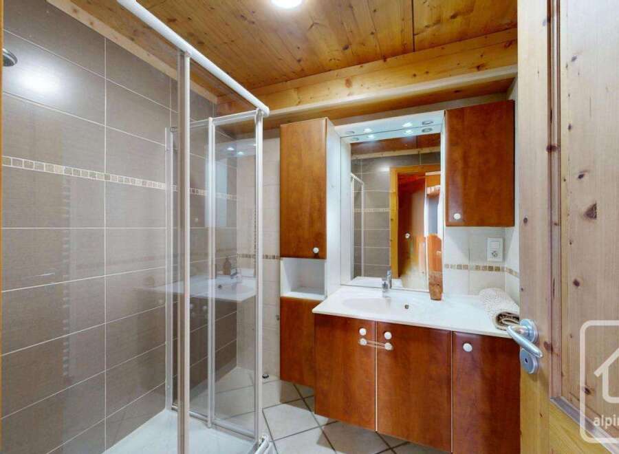 Discover this charming bathroom featuring a sleek glass shower enclosure and elegant tile work.