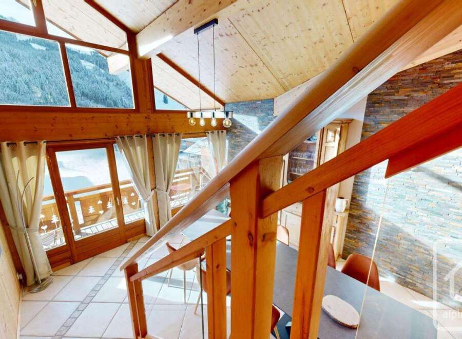 Experience the charm of this stunning property, featuring a beautifully crafted wooden staircase and a cozy interior.
