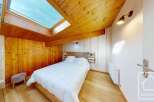This charming bedroom features a cozy wooden ceiling and walls, creating a warm and inviting atmosphere.