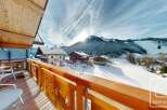 Enjoy breathtaking mountain views from this charming chalet balcony.