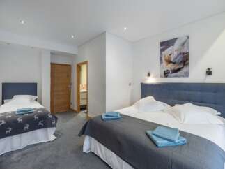 This cozy bedroom features two beds, perfect for a family or group of friends.