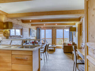 Experience the charm of this stunning property, featuring a cozy living space with wooden accents and a modern kitchen.