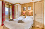 Experience the charm of this cozy bedroom, featuring a warm wooden interior and a comfortable bed.