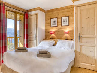Experience the charm of this cozy bedroom, featuring a warm wooden interior and a comfortable bed.