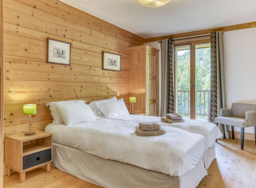 This cozy bedroom features a warm wooden wall and flooring, creating a rustic and inviting atmosphere.