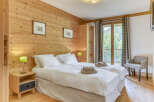 This cozy bedroom features a warm wooden wall and flooring, creating a rustic and inviting atmosphere.