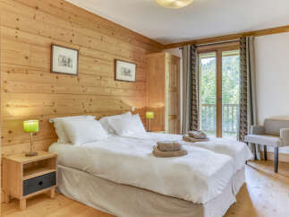 This cozy bedroom features a warm wooden wall and flooring, creating a rustic and inviting atmosphere.
