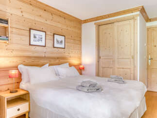 This cozy bedroom features beautiful wooden paneling, creating a warm and inviting atmosphere.