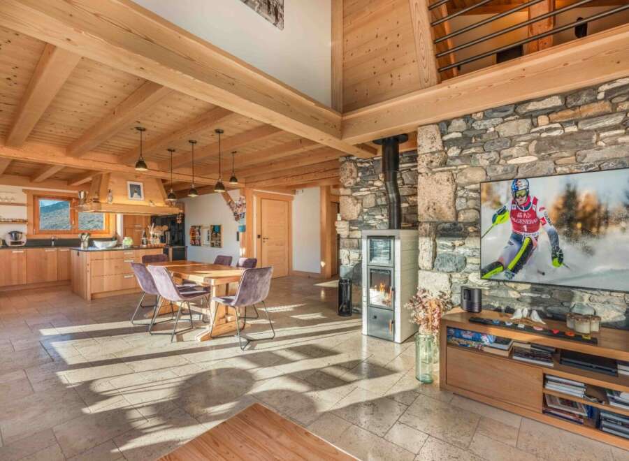 Experience the warmth of this stunning chalet, featuring a cozy fireplace and exposed wooden beams.