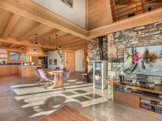 Experience the warmth of this stunning chalet, featuring a cozy fireplace and exposed wooden beams.