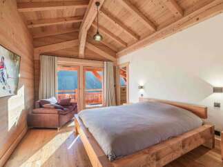 Experience the warmth and charm of this stunning bedroom, featuring a beautiful wooden ceiling and walls.