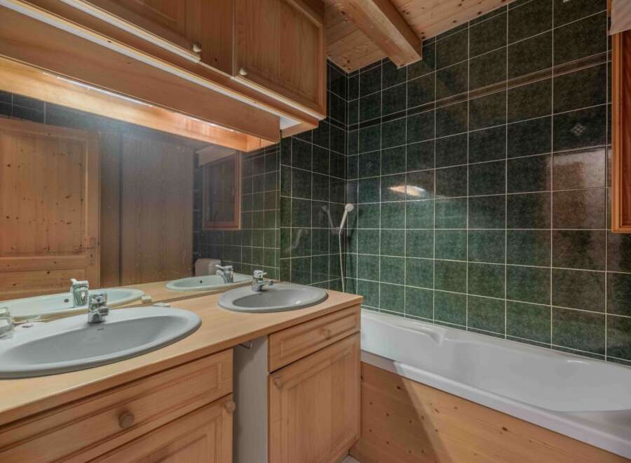 This charming bathroom features a rustic design with wooden cabinets and a matching vanity.