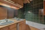 This charming bathroom features a rustic design with wooden cabinets and a matching vanity.