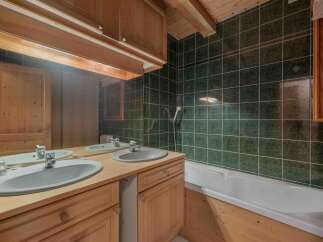 This charming bathroom features a rustic design with wooden cabinets and a matching vanity.