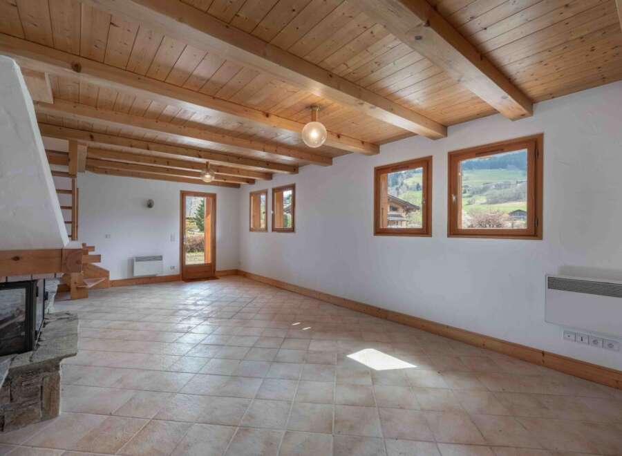 Discover the charm of this inviting living space, featuring a stunning wooden ceiling and exposed beams that add warmth and character.