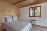 This charming bedroom features a cozy wooden ceiling and walls, creating a warm and inviting atmosphere.