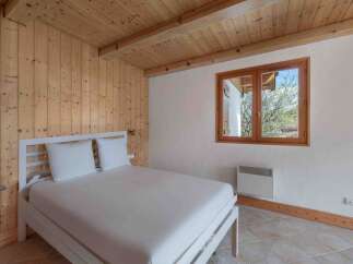 This charming bedroom features a cozy wooden ceiling and walls, creating a warm and inviting atmosphere.