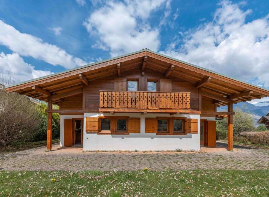 This stunning chalet-style home boasts exquisite wooden architecture and a charming balcony, perfect for enjoying the scenic views.