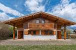 This stunning chalet-style home boasts exquisite wooden architecture and a charming balcony, perfect for enjoying the scenic views.